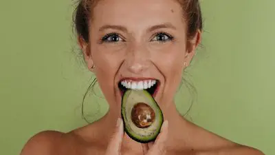 Woman eating an avocado