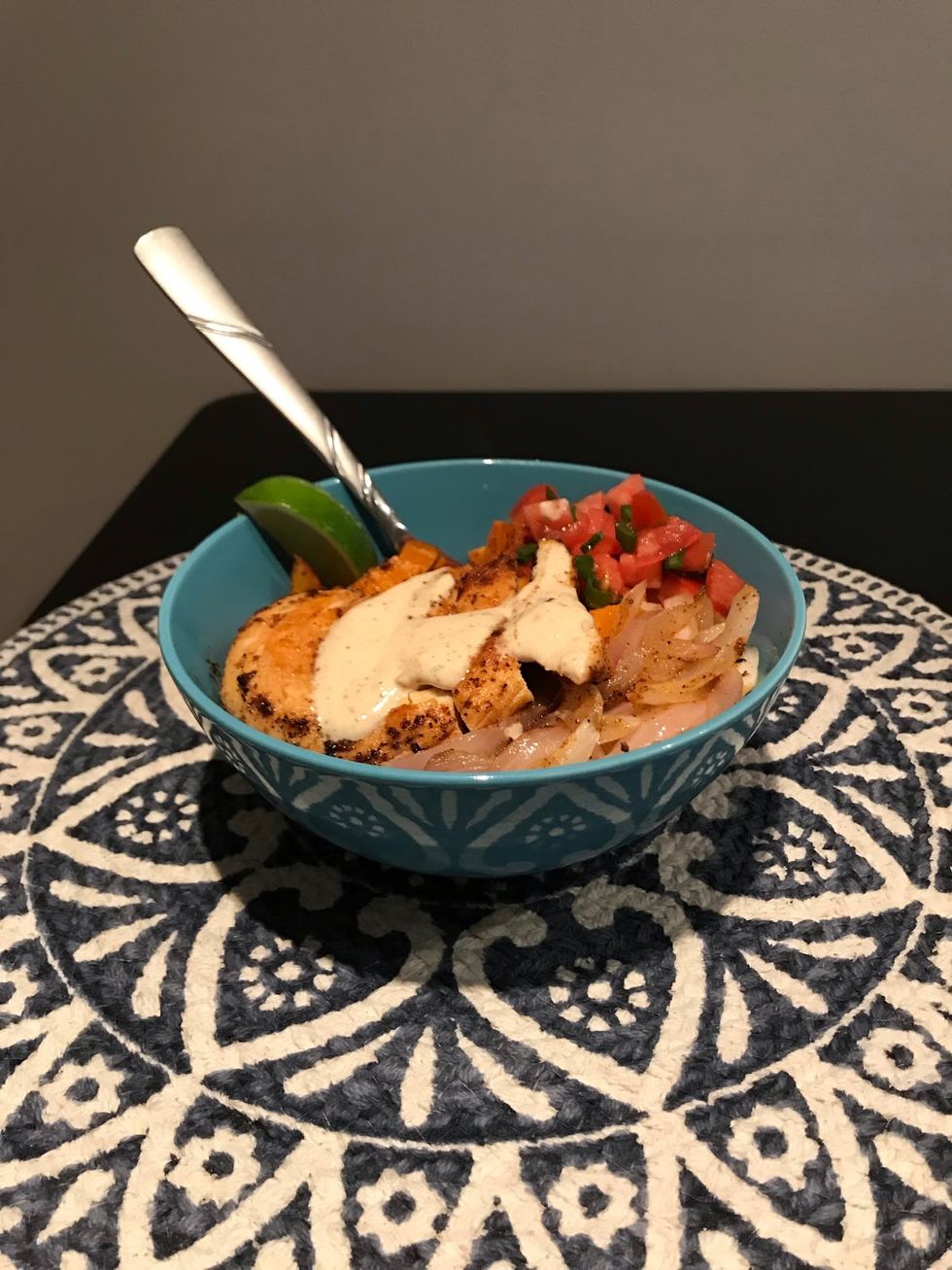 chicken with crema and veggies in a blue bowl with a blue tablecloth