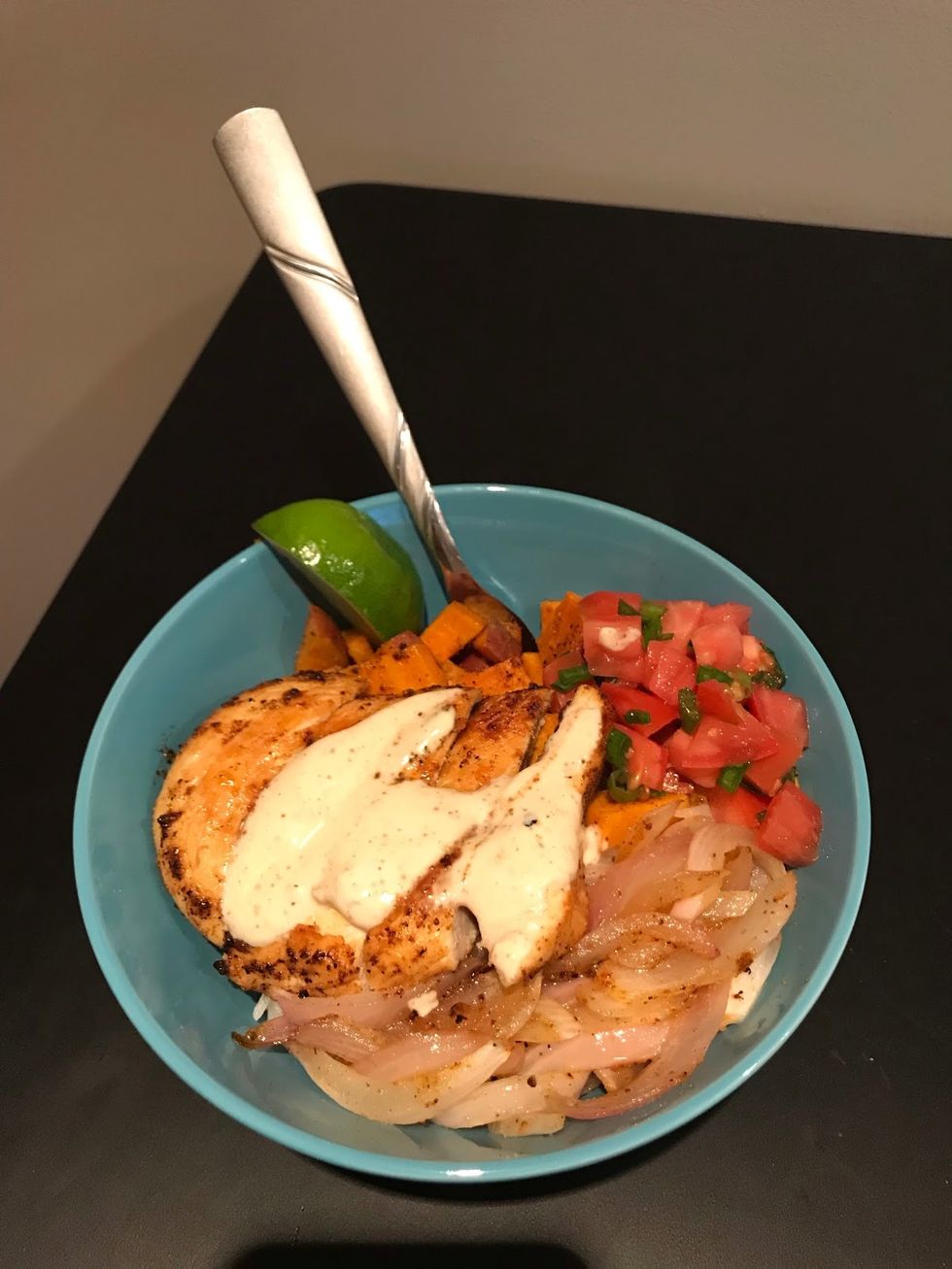 chicken with crema and vegetables in a blue bowl