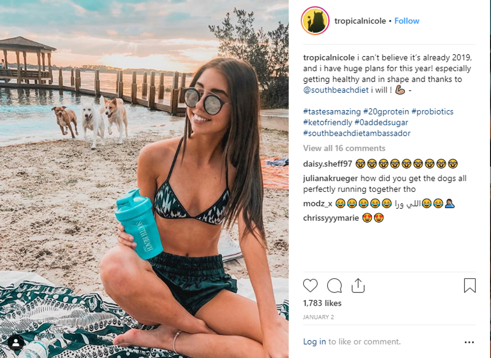 brown haired girl with south beach cup and dogs on the beach