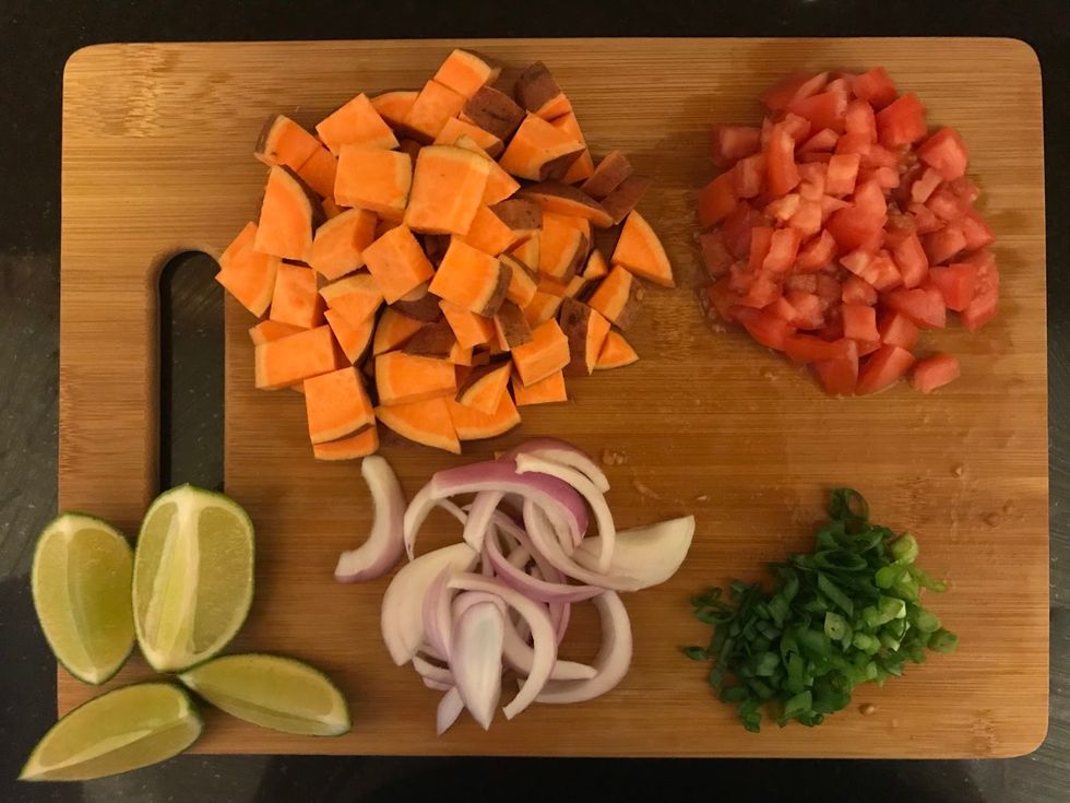 sweet potatoes, limes, onion, cilantro and tomatoes on a cutting board
