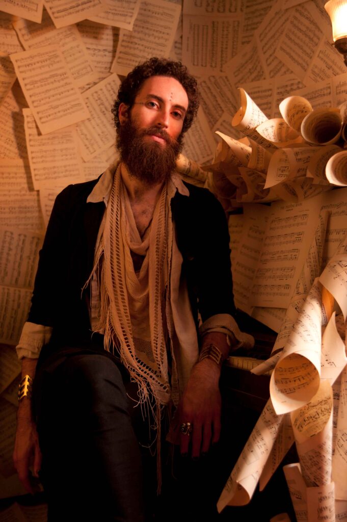 Luis Mojica sitting with paper behind him 