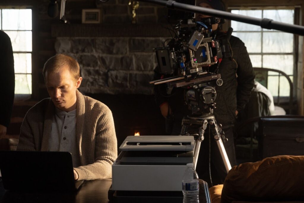 The Writer - Film Still with Jefferson White typing on a keyboard