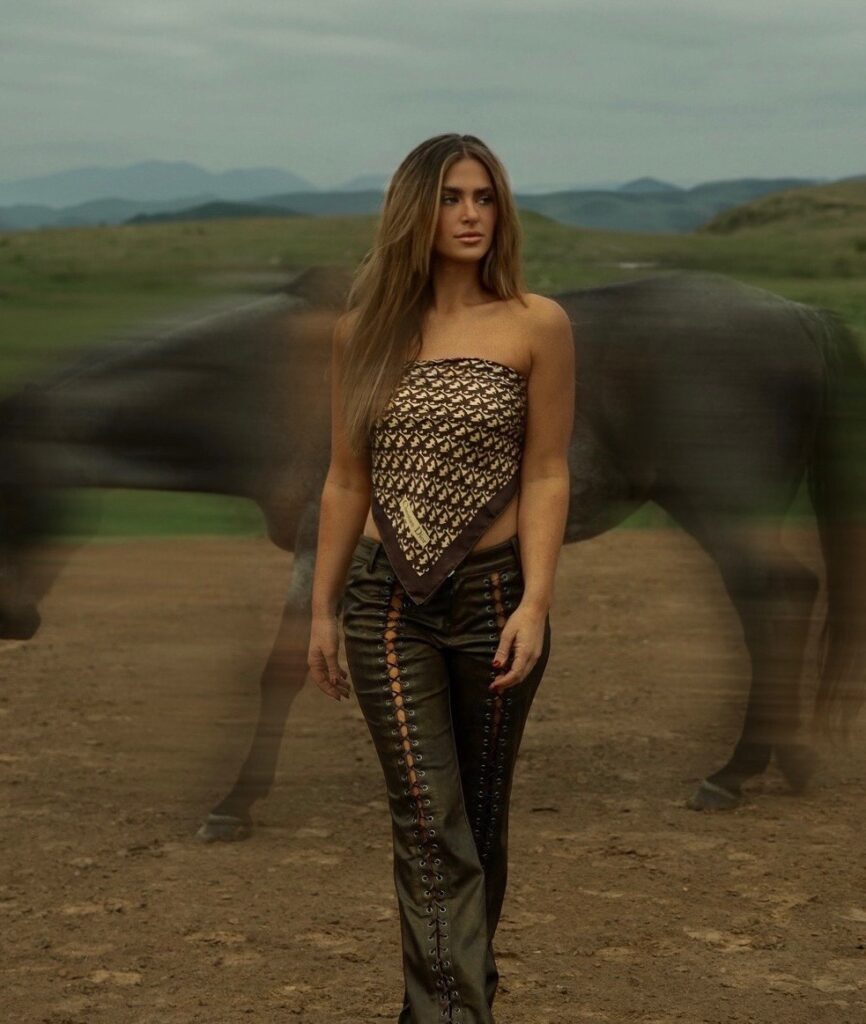 Kat walking with a blurry horse in the background
